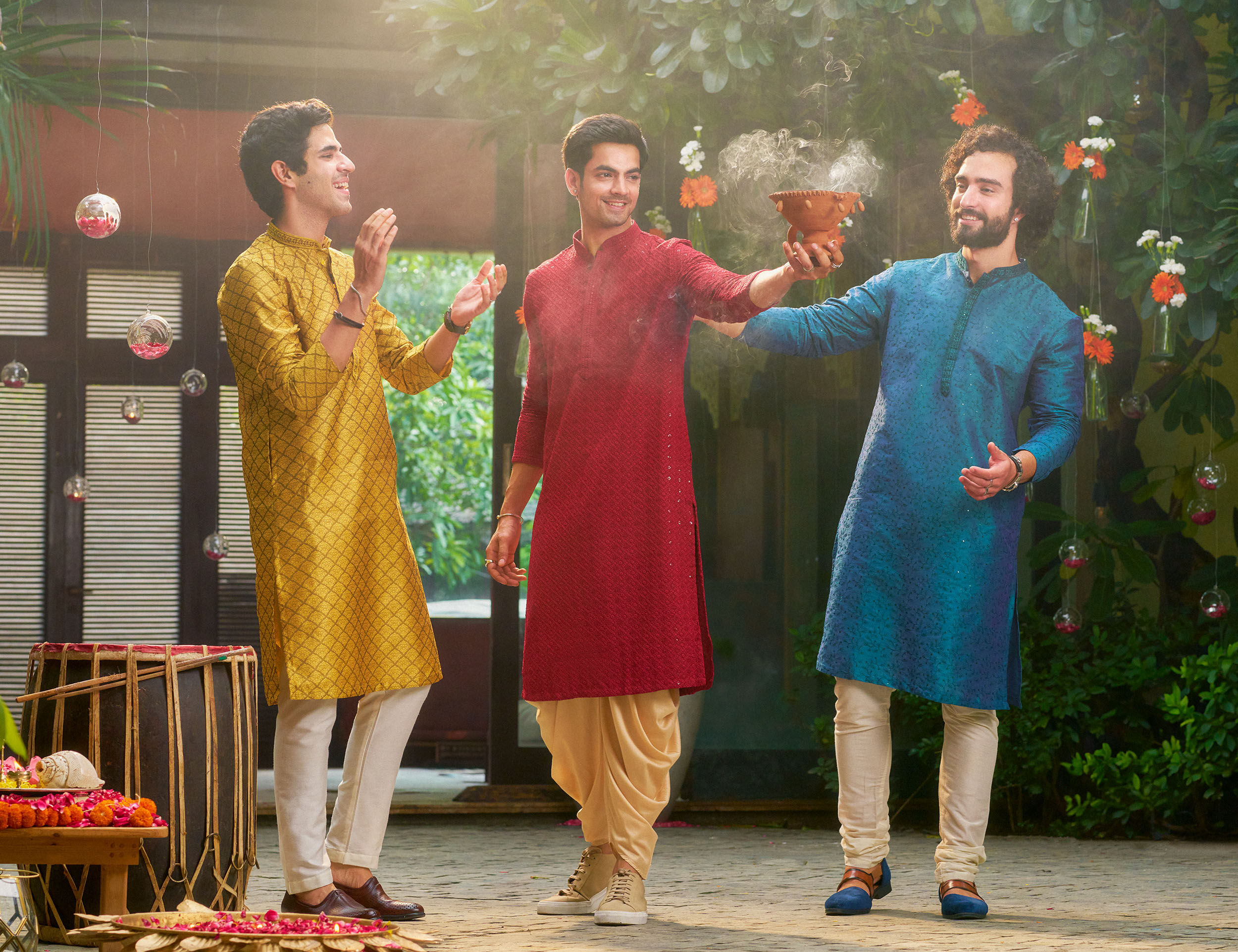 Men in vibrant traditional kurtas performing Durga Puja rituals with dhunuchi dance and festive energy